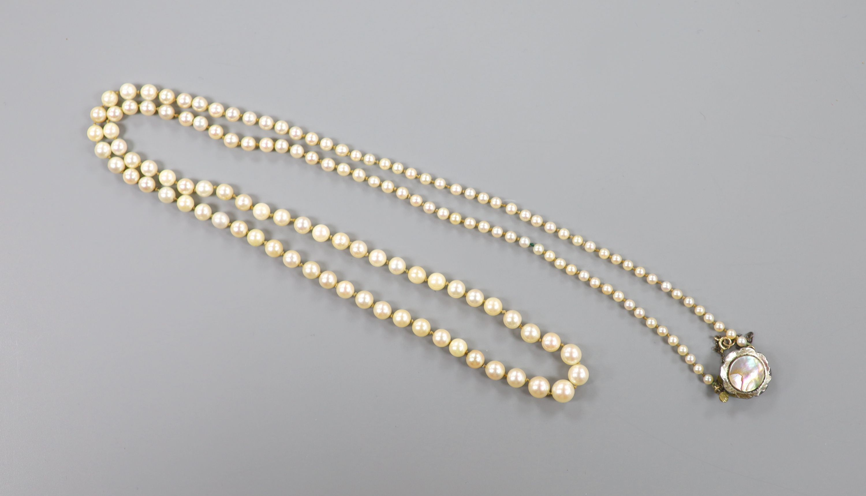 A single strand graduated cultured pearl necklace, with paur shell set clasp, 86cm.